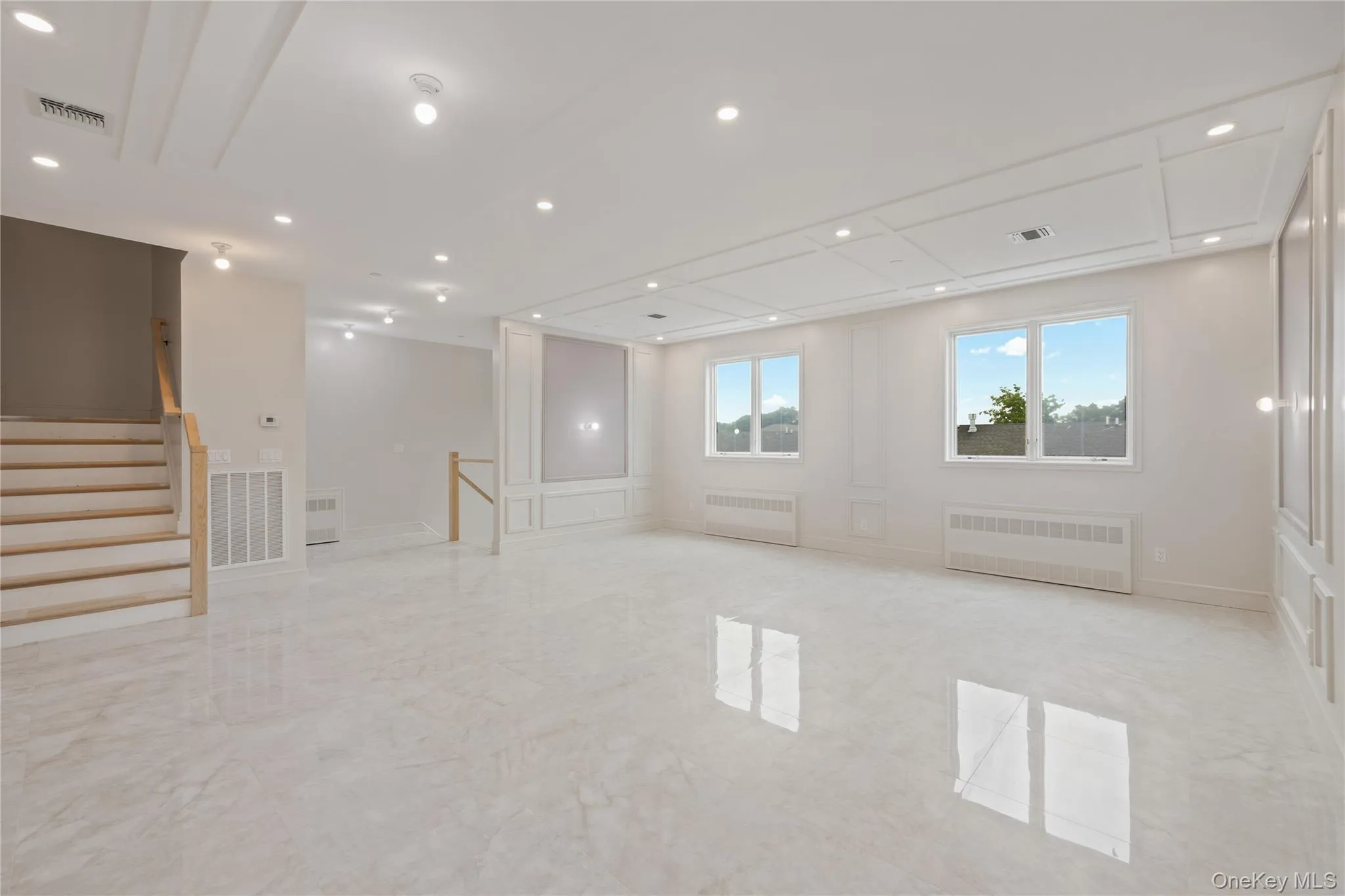 Spare room with radiator, light marble finish floors, recessed lighting, and stairway Spare room with radiator, light marble finish floors, recessed lighting, and stairway