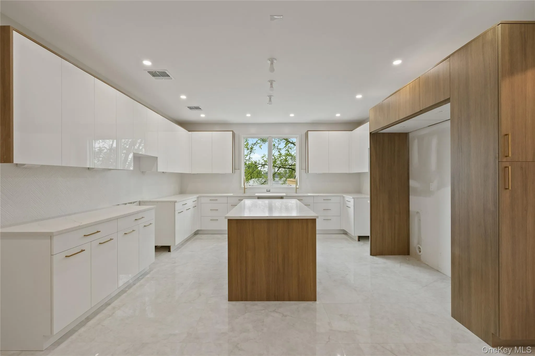 Kitchen featuring a center island, modern cabinets, light marble finish floors, white cabinetry, and recessed lighting Kitchen featuring a center island, modern cabinets, light marble finish floors, white cabinetry, and recessed lighting