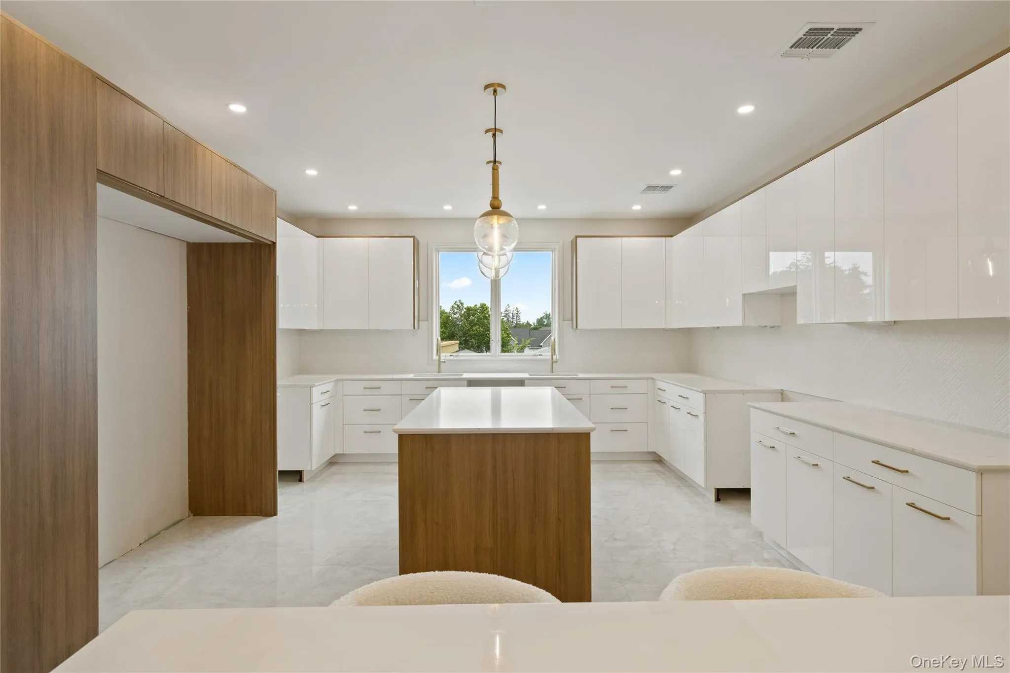 Kitchen with a kitchen island, modern cabinets, white cabinets, pendant lighting, and recessed lighting Kitchen with a kitchen island, modern cabinets, white cabinets, pendant lighting, and recessed lighting