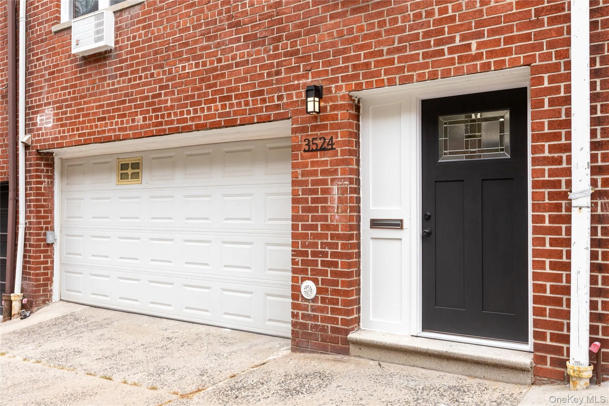 Entrance to property with brick siding, a garage, and driveway Entrance to property with brick siding, a garage, and driveway
