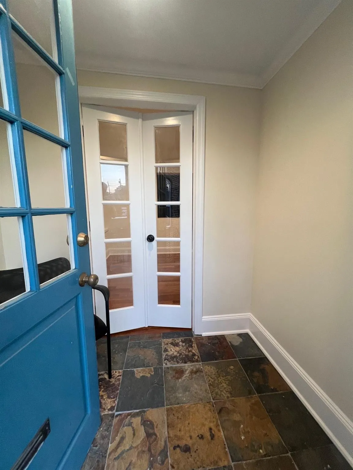 Entryway featuring dark stone finish floors, ornamental molding, and french doors Entryway featuring dark stone finish floors, ornamental molding, and french doors