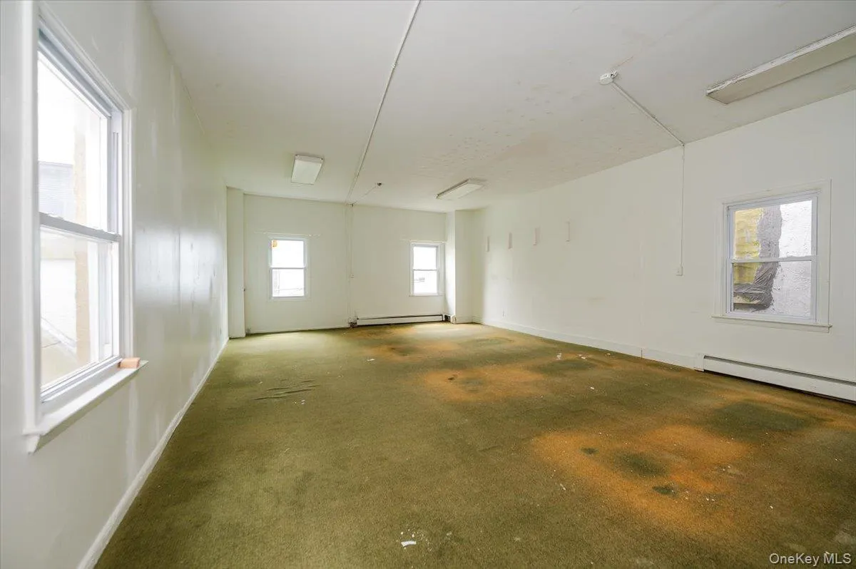 Empty room with baseboards and carpet flooring Empty room with baseboards and carpet flooring