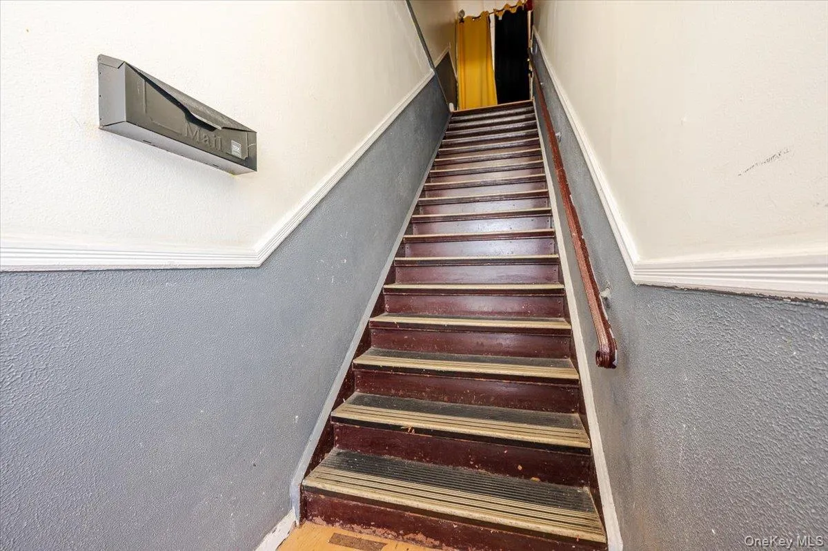 Stairway featuring a textured wall and wood finished floors Stairway featuring a textured wall and wood finished floors