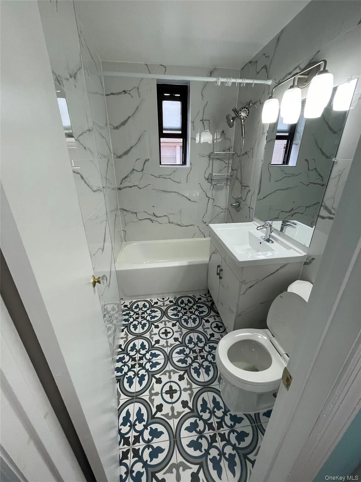 Bathroom featuring washtub / shower combination, vanity, and tile patterned floors Bathroom featuring washtub / shower combination, vanity, and tile patterned floors