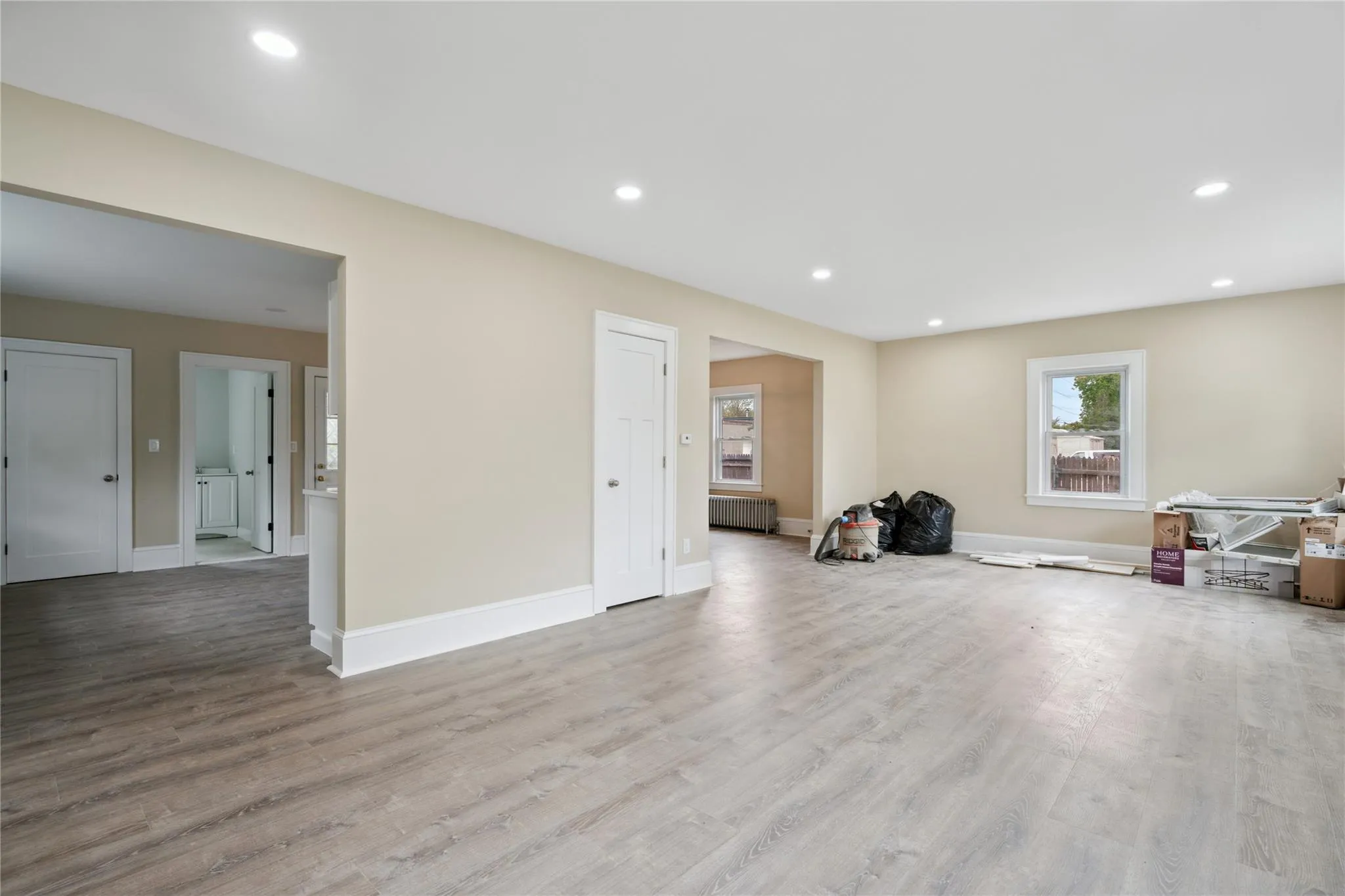 Unfurnished room featuring radiator, recessed lighting, and wood finished floors Unfurnished room featuring radiator, recessed lighting, and wood finished floors