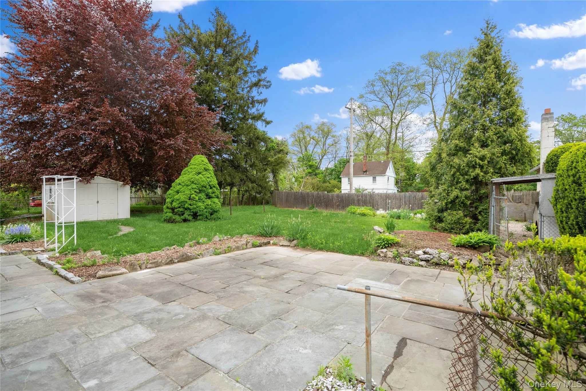 Fenced backyard with a patio and a storage shed Fenced backyard with a patio and a storage shed