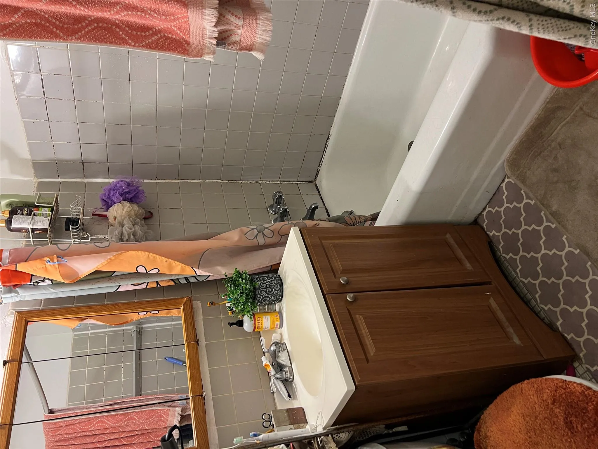 Full bath with backsplash, vanity, bathtub / shower combination, and tile walls Full bath with backsplash, vanity, bathtub / shower combination, and tile walls