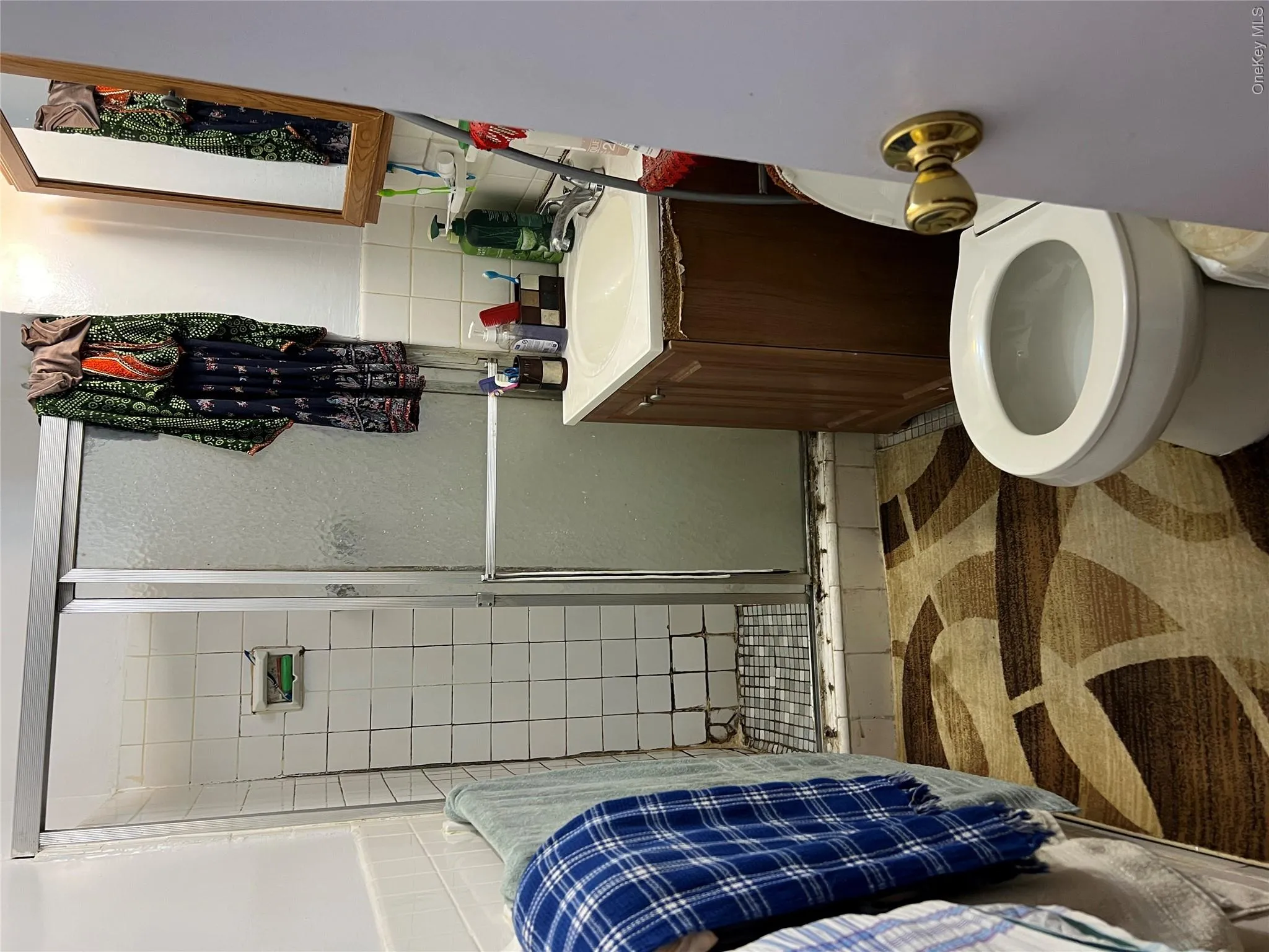 Bathroom with tile walls, a stall shower, vanity, and a wainscoted wall Bathroom with tile walls, a stall shower, vanity, and a wainscoted wall