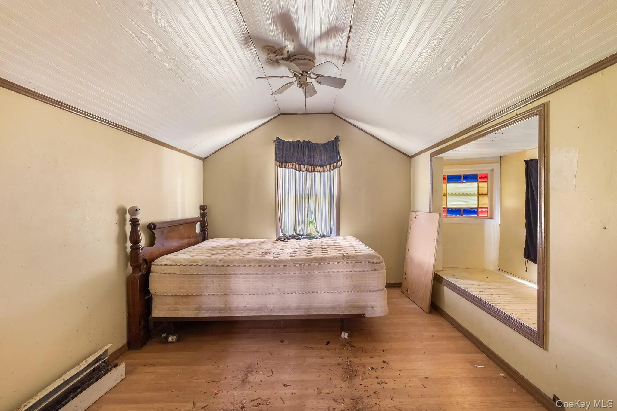 Bedroom with light wood finished floors, vaulted ceiling, ceiling fan, and ornamental molding Bedroom with light wood finished floors, vaulted ceiling, ceiling fan, and ornamental molding