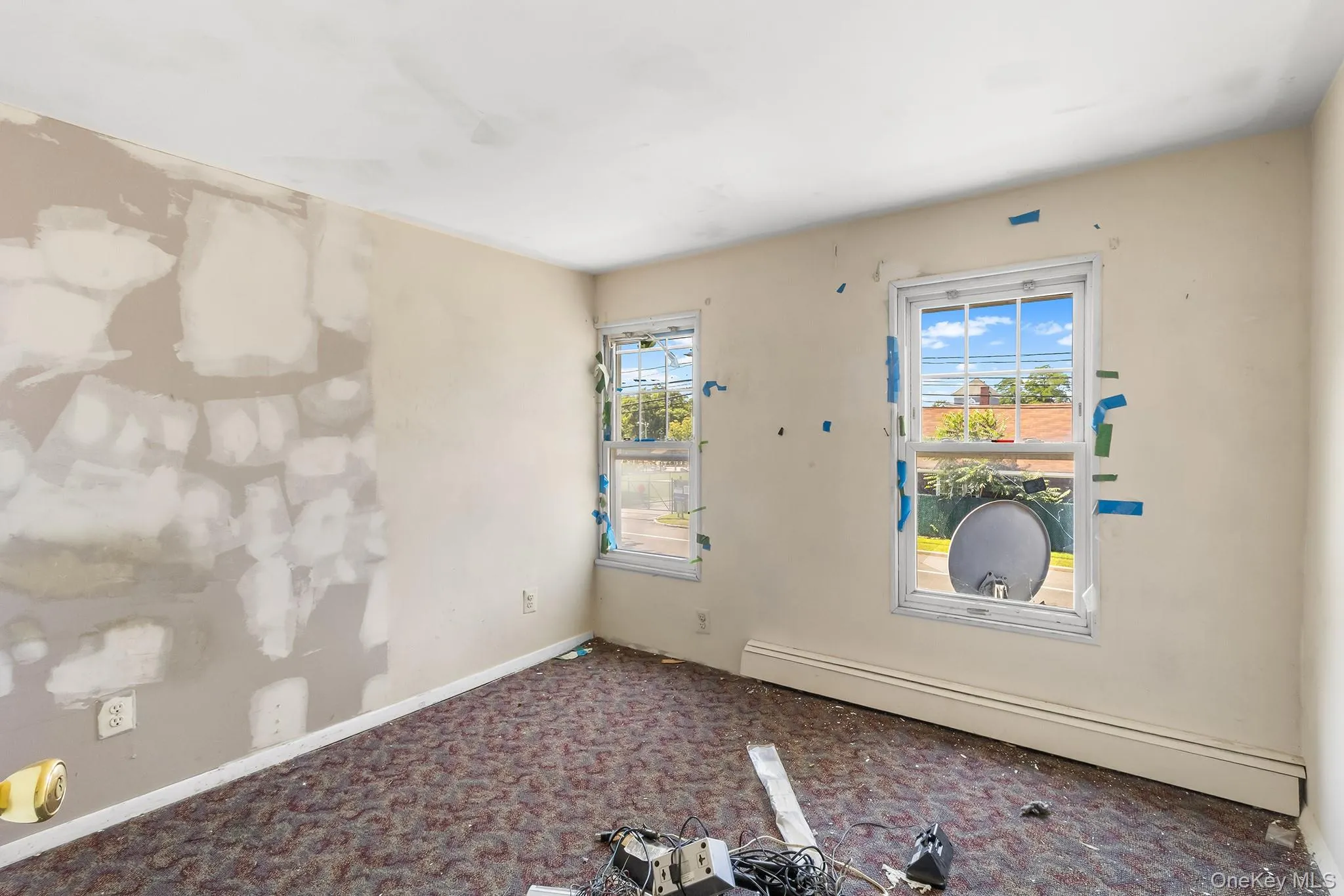 Unfurnished room with carpet floors, a baseboard radiator, and plenty of natural light Unfurnished room with carpet floors, a baseboard radiator, and plenty of natural light