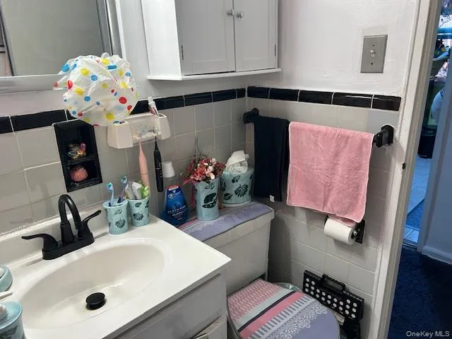 Half bath with tile walls and vanity Half bath with tile walls and vanity