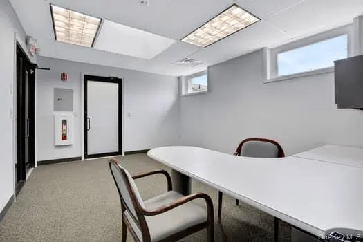 Office with a drop ceiling and light carpet Office with a drop ceiling and light carpet