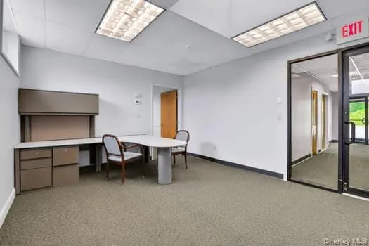 Office space with light colored carpet and a drop ceiling Office space with light colored carpet and a drop ceiling