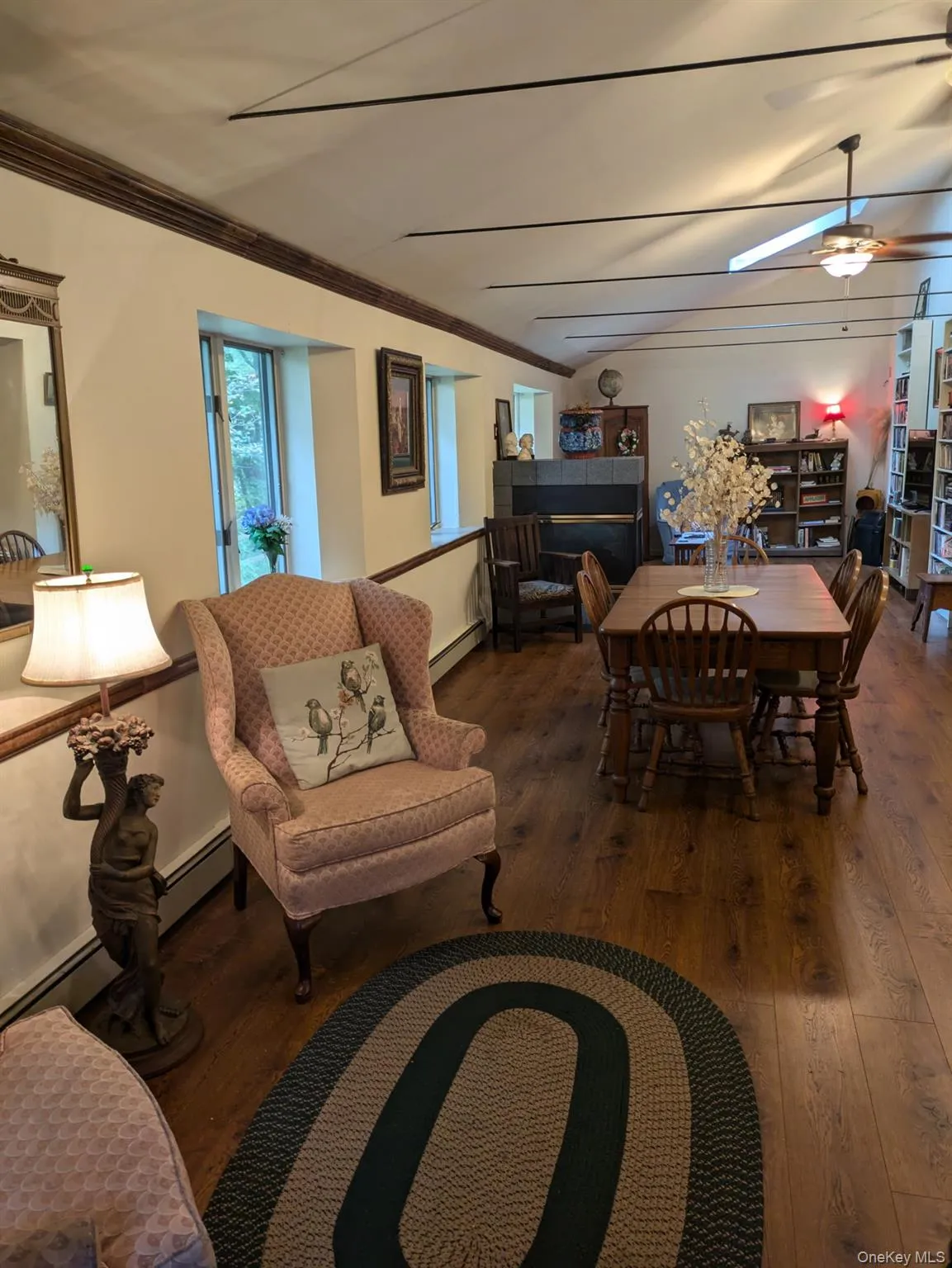Dining room with ornamental molding, dark wood-type flooring, baseboard heating, and ceiling fan Dining room with ornamental molding, dark wood-type flooring, baseboard heating, and ceiling fan
