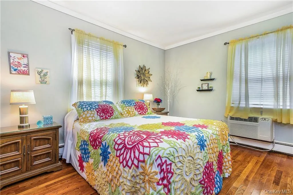 Bedroom with hardwood / wood-style flooring, crown molding, and baseboard heating Bedroom with hardwood / wood-style flooring, crown molding, and baseboard heating