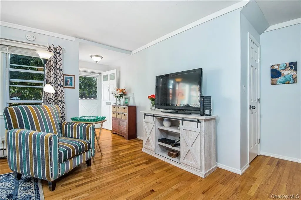 Sitting room featuring ornamental molding and light wood finished floors Sitting room featuring ornamental molding and light wood finished floors