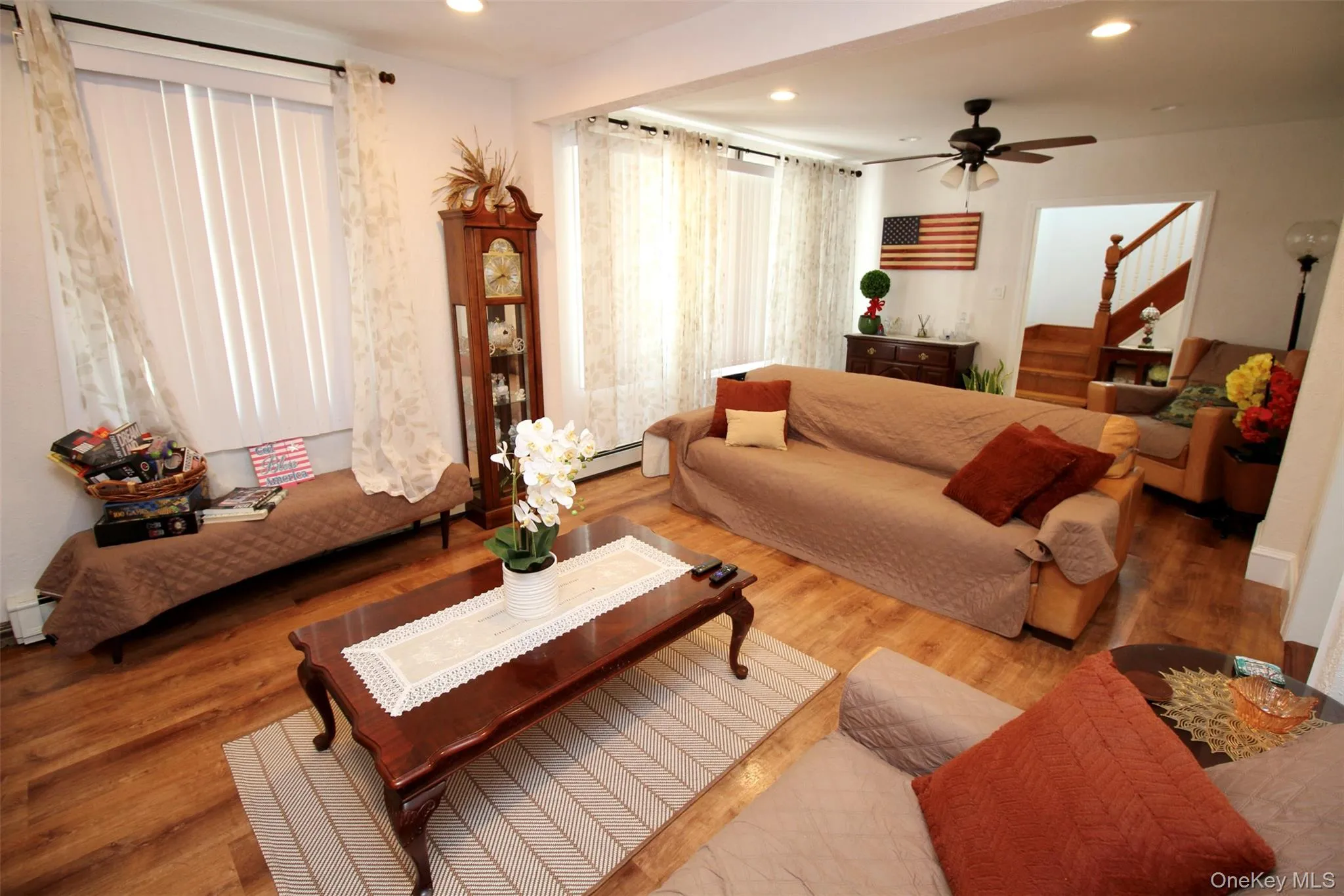 Living area with wood finished floors, stairs, recessed lighting, a ceiling fan, and a baseboard radiator Living area with wood finished floors, stairs, recessed lighting, a ceiling fan, and a baseboard radiator