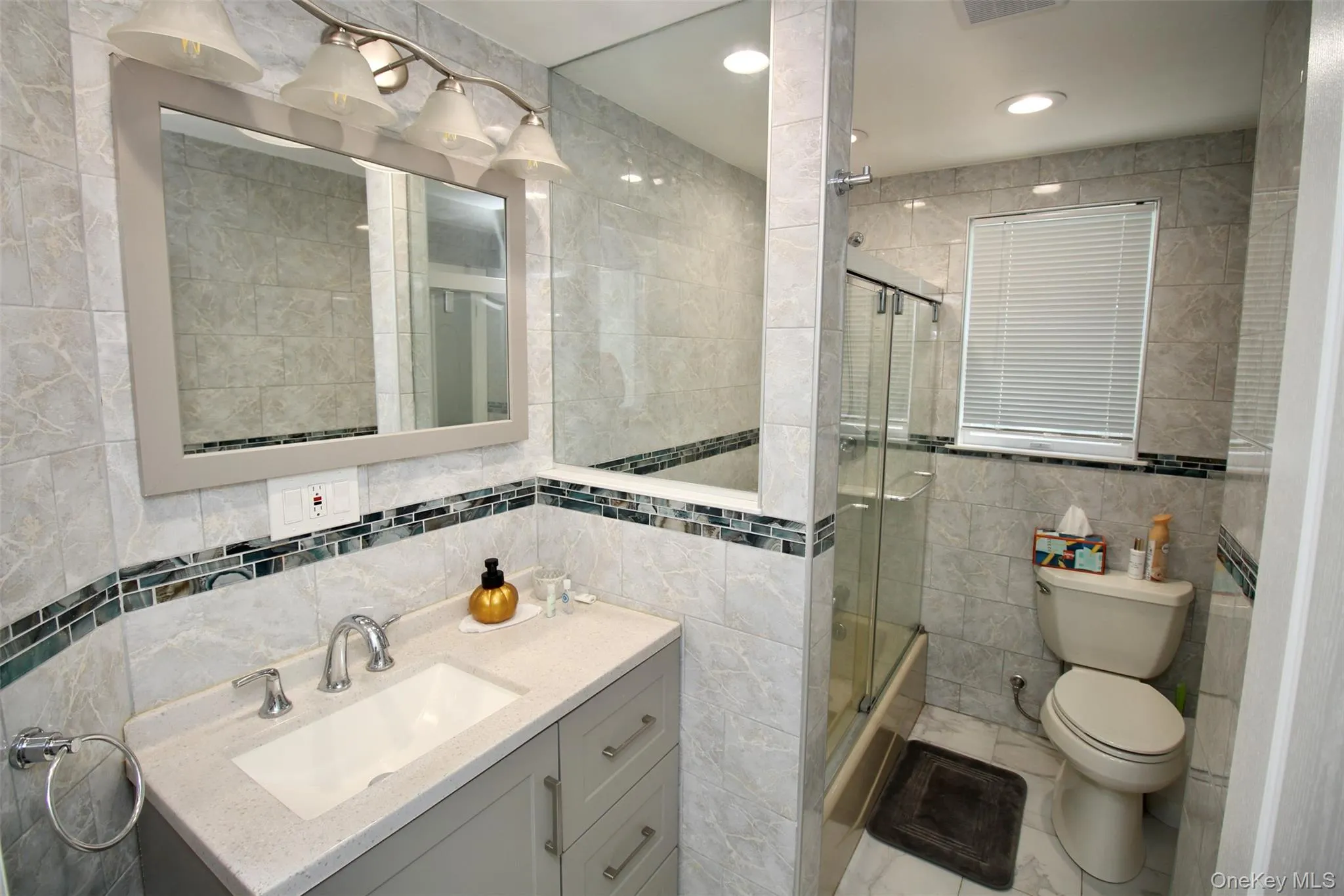 Bathroom featuring tile walls, vanity, a shower stall, and recessed lighting Bathroom featuring tile walls, vanity, a shower stall, and recessed lighting