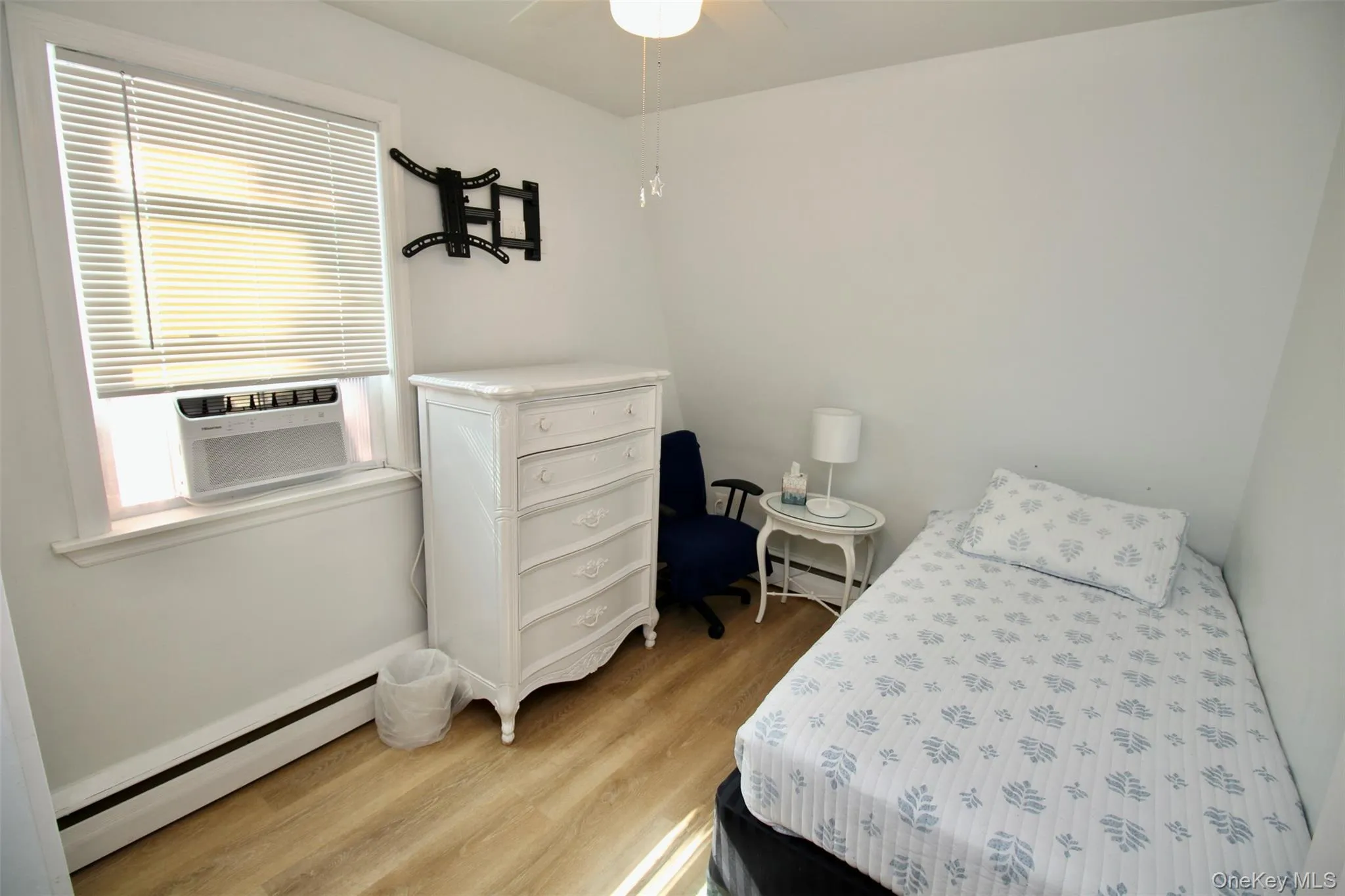 Bedroom with baseboard heating, light wood-style flooring, ceiling fan, and a baseboard radiator Bedroom with baseboard heating, light wood-style flooring, ceiling fan, and a baseboard radiator
