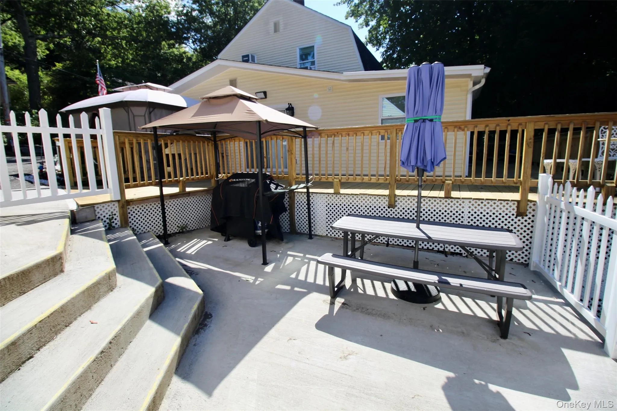 View of patio with a gazebo, a wooden deck, grilling area, and outdoor dining space View of patio with a gazebo, a wooden deck, grilling area, and outdoor dining space