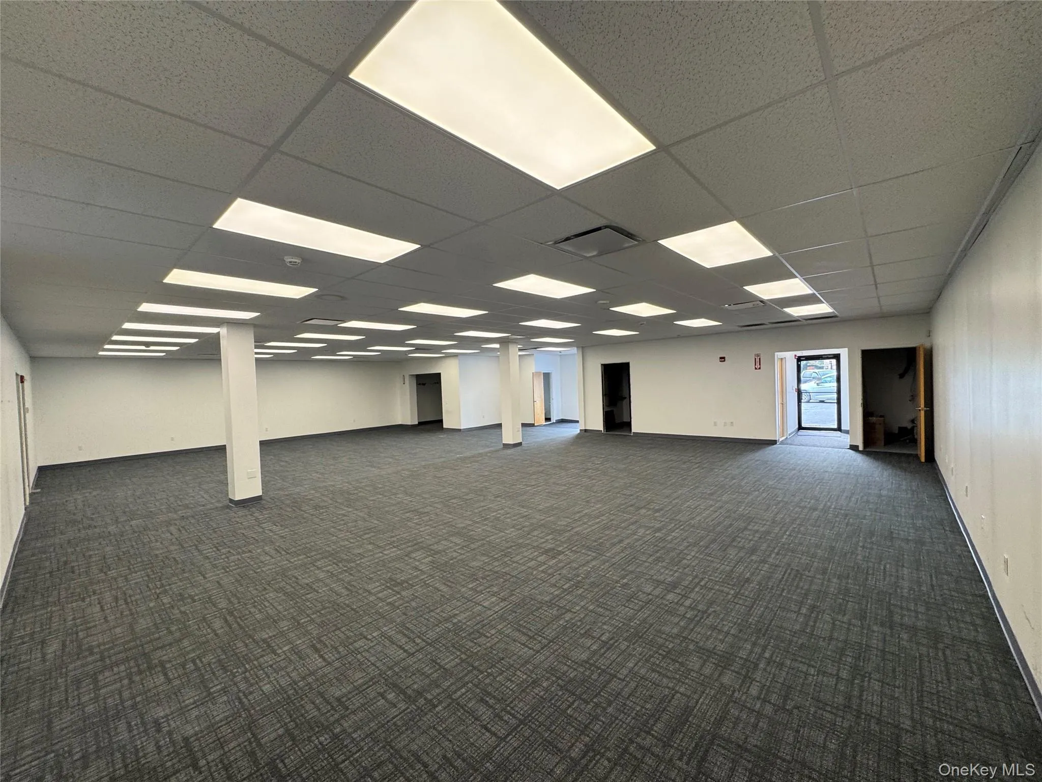 Unfurnished room with dark carpet and baseboards Unfurnished room with dark carpet and baseboards