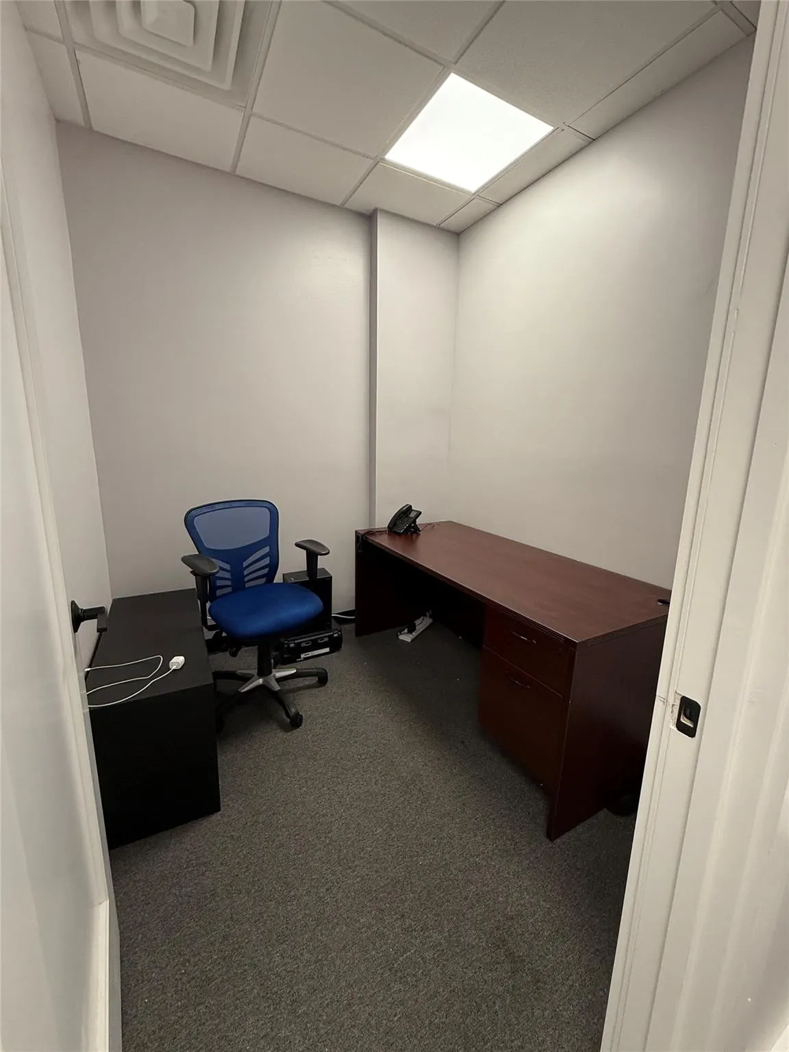 Carpeted office featuring a drop ceiling Carpeted office featuring a drop ceiling