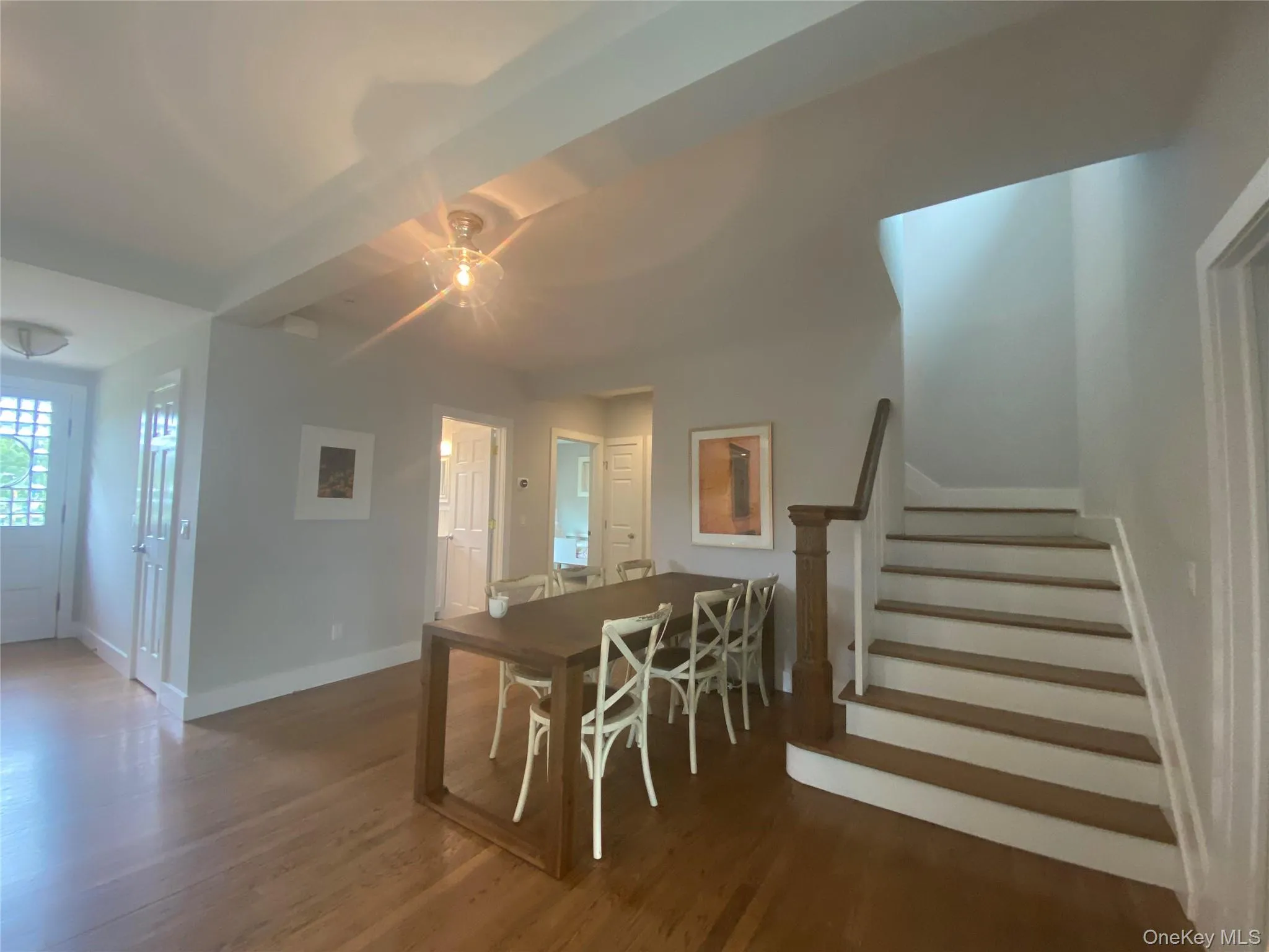 Dining area featuring stairs and wood finished floors Dining area featuring stairs and wood finished floors