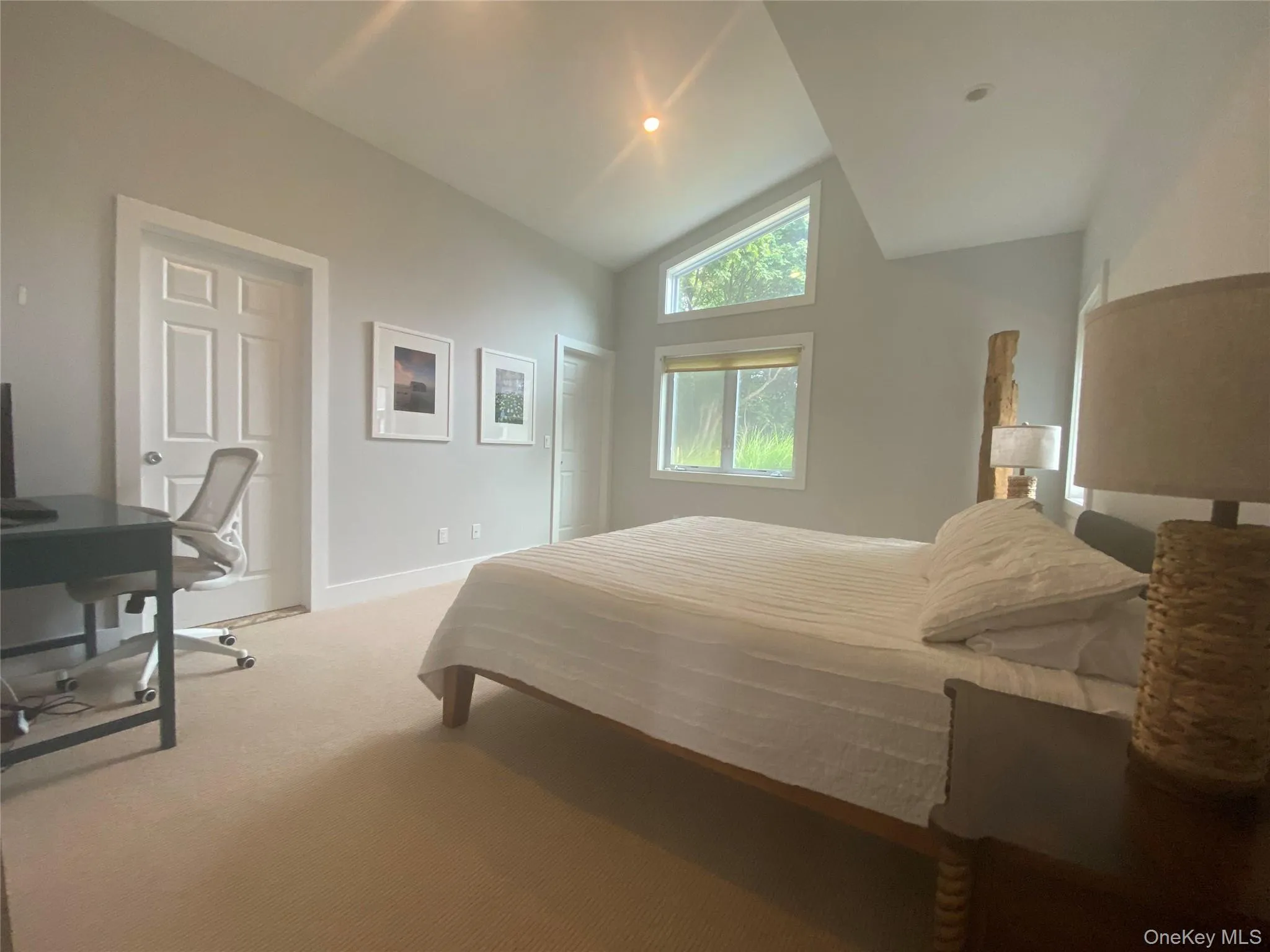 Carpeted bedroom featuring a desk and high vaulted ceiling Carpeted bedroom featuring a desk and high vaulted ceiling