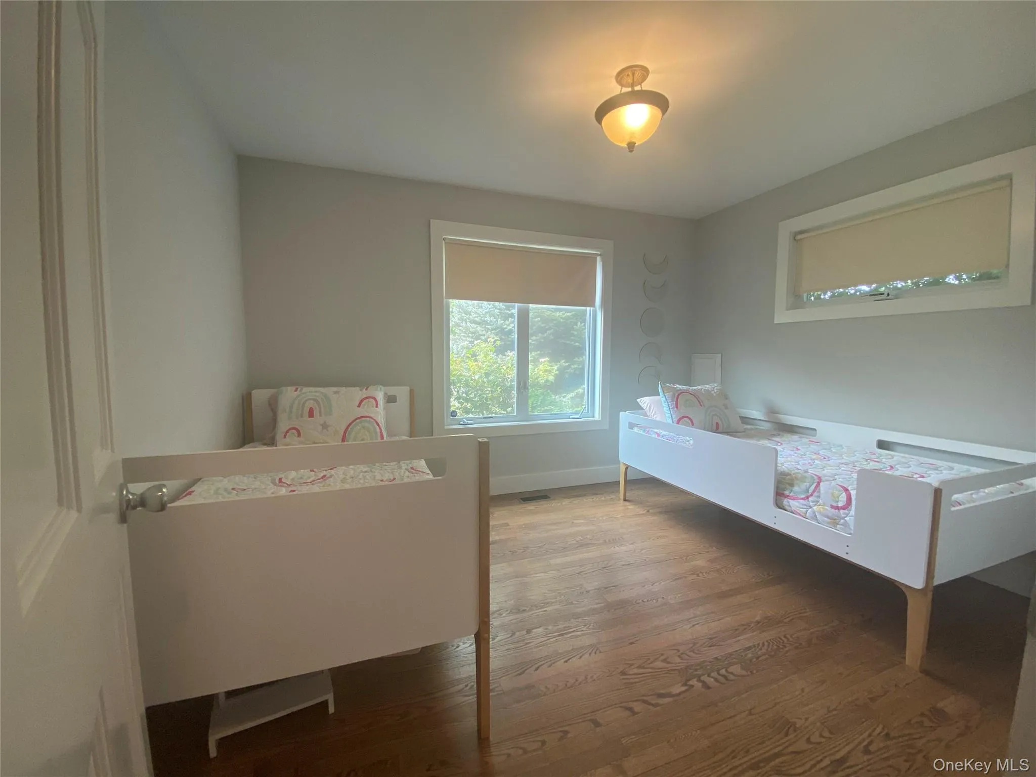Bedroom featuring wood finished floors and baseboards Bedroom featuring wood finished floors and baseboards