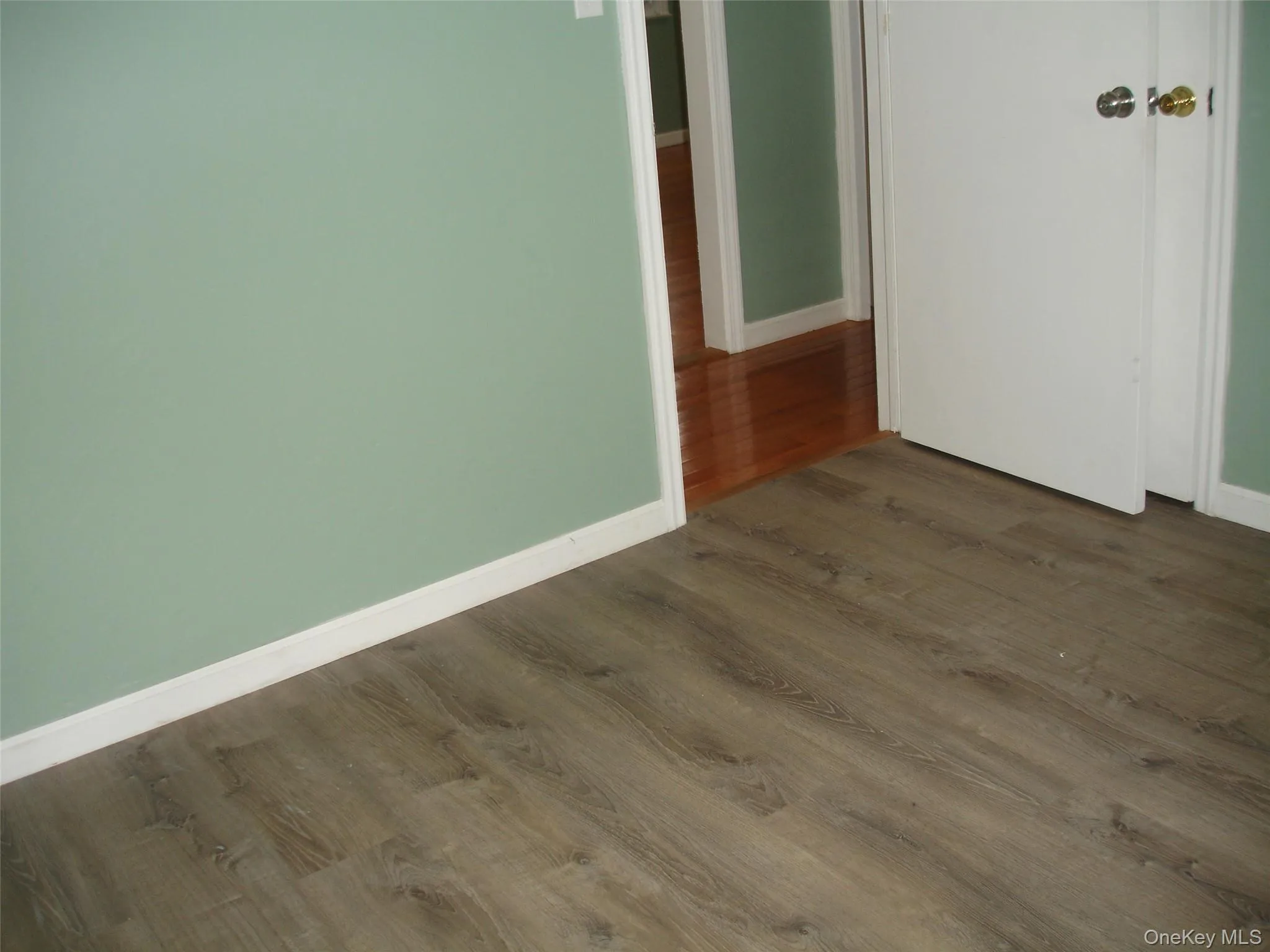 Empty room featuring dark wood finished floors and baseboards Empty room featuring dark wood finished floors and baseboards