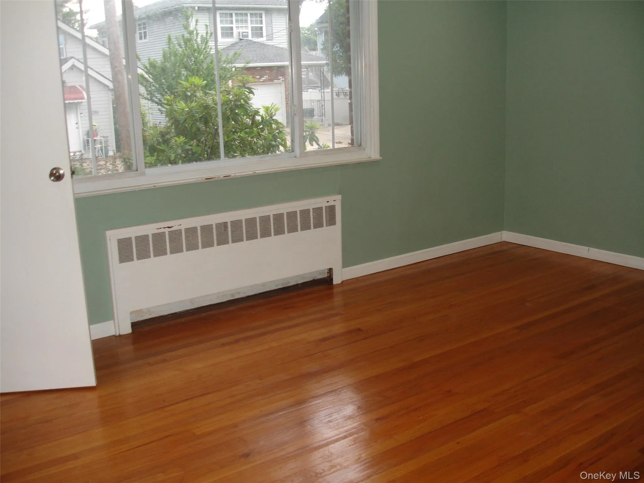 Empty room with radiator and wood finished floors Empty room with radiator and wood finished floors