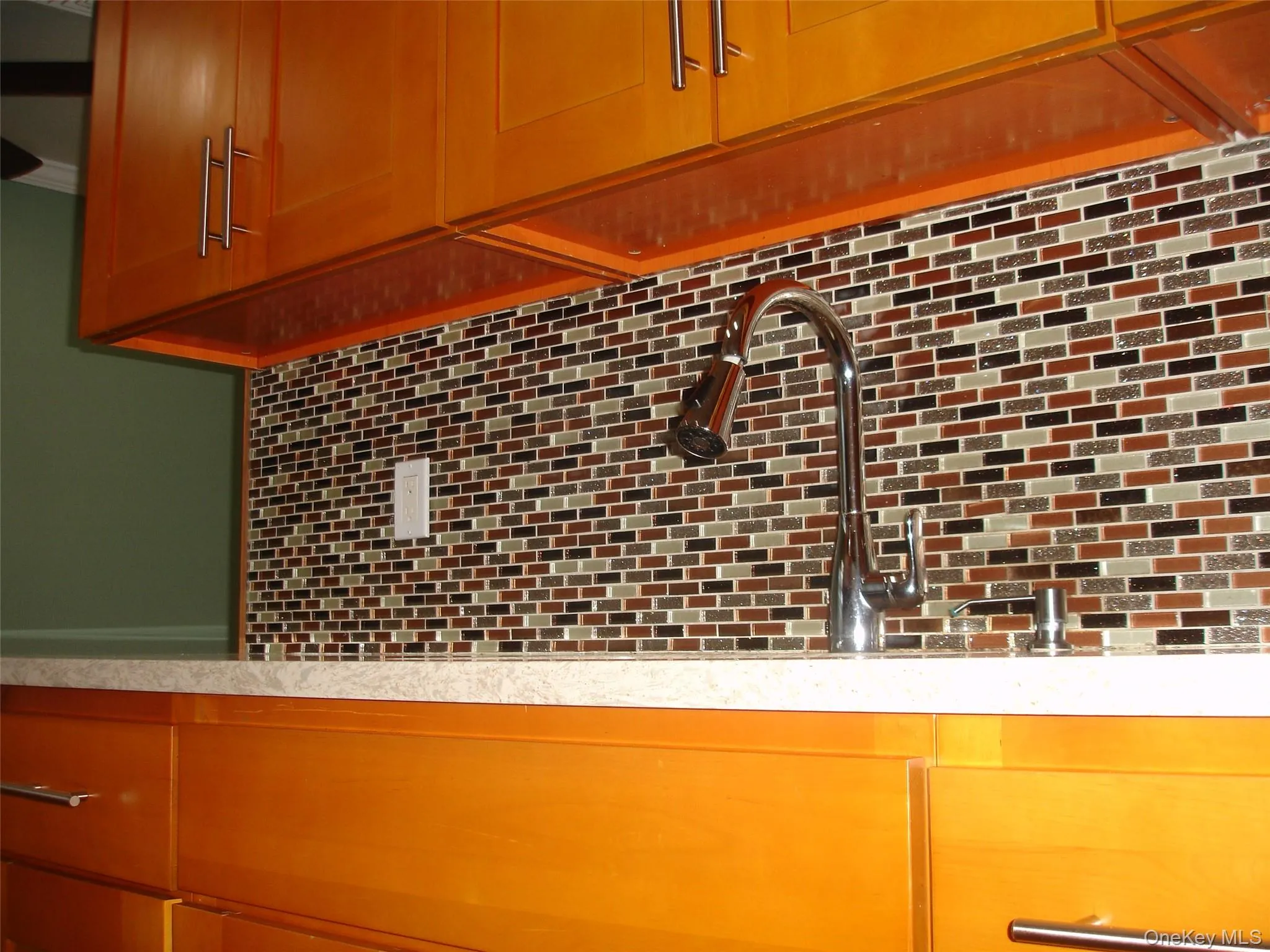 Kitchen view of backsplash, light countertops, and bar Kitchen view of backsplash, light countertops, and bar