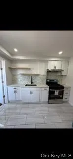 Kitchen featuring stainless steel range with electric cooktop, backsplash, recessed lighting, white cabinets, and light countertops Kitchen featuring stainless steel range with electric cooktop, backsplash, recessed lighting, white cabinets, and light countertops