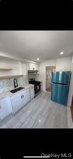 Kitchen featuring freestanding refrigerator, white cabinets, stainless steel range, decorative backsplash, and recessed lighting Kitchen featuring freestanding refrigerator, white cabinets, stainless steel range, decorative backsplash, and recessed lighting