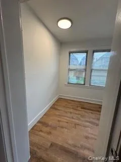Empty room featuring wood finished floors and baseboards Empty room featuring wood finished floors and baseboards