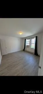 Spare room featuring wood finished floors and baseboard heating Spare room featuring wood finished floors and baseboard heating