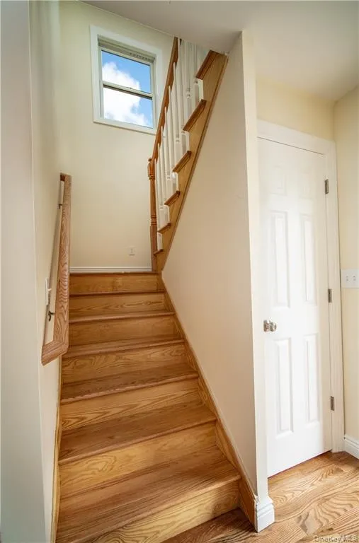 Stairway featuring baseboards and wood finished floors Stairway featuring baseboards and wood finished floors