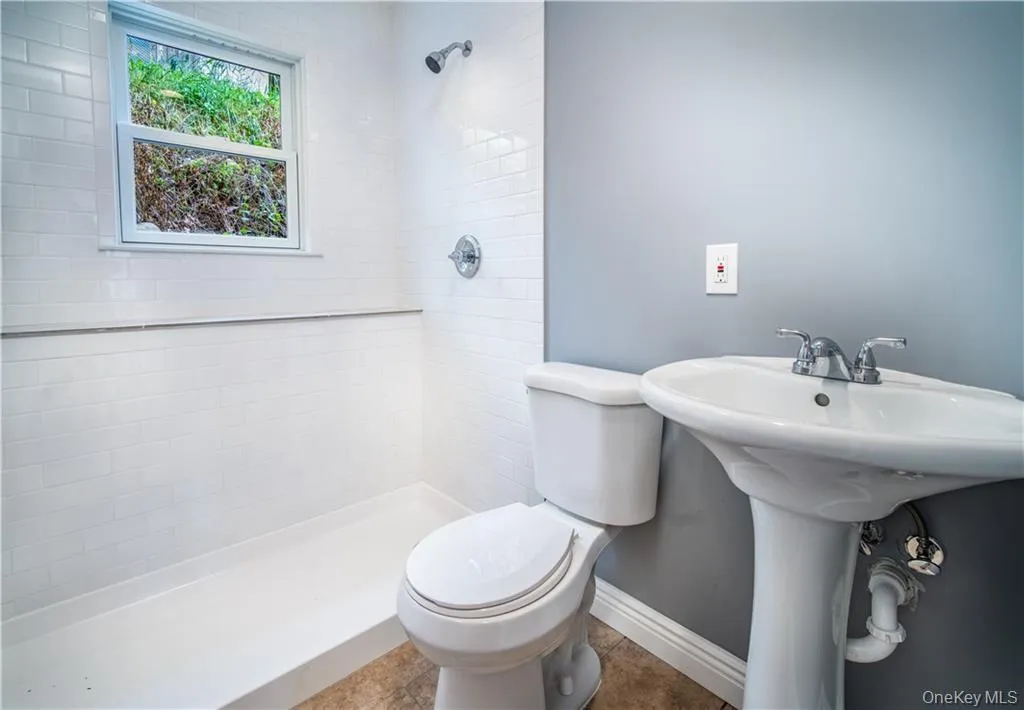 Full bathroom featuring tiled shower and toilet Full bathroom featuring tiled shower and toilet