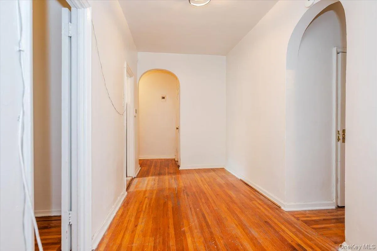 Dining room with arched entrance and wood finished floors Dining room with arched entrance and wood finished floors
