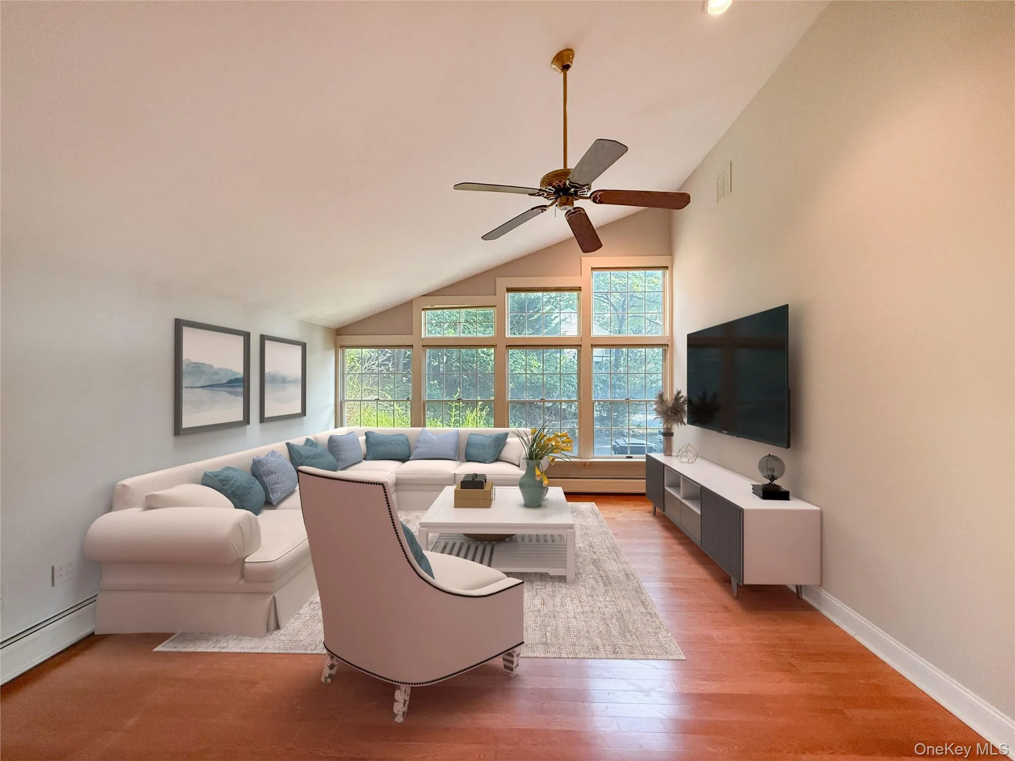 Living area with high vaulted ceiling, light wood-type flooring, ceiling fan, and a baseboard radiator Living area with high vaulted ceiling, light wood-type flooring, ceiling fan, and a baseboard radiator