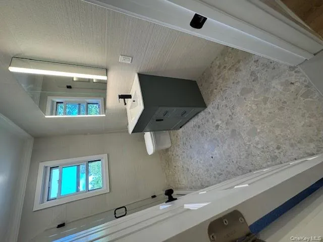 Bathroom featuring vanity, crown molding, and tile walls Bathroom featuring vanity, crown molding, and tile walls