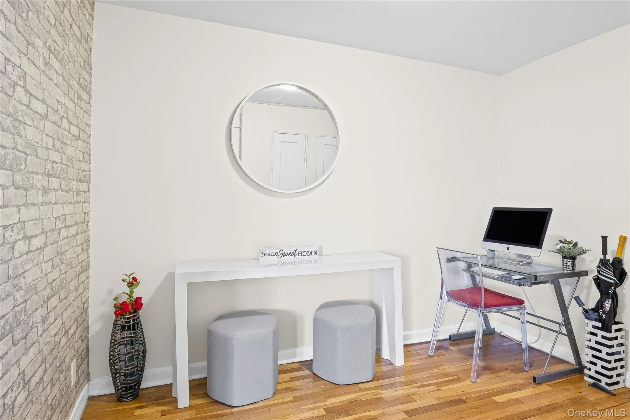 Office space featuring wood finished floors and brick wall Office space featuring wood finished floors and brick wall