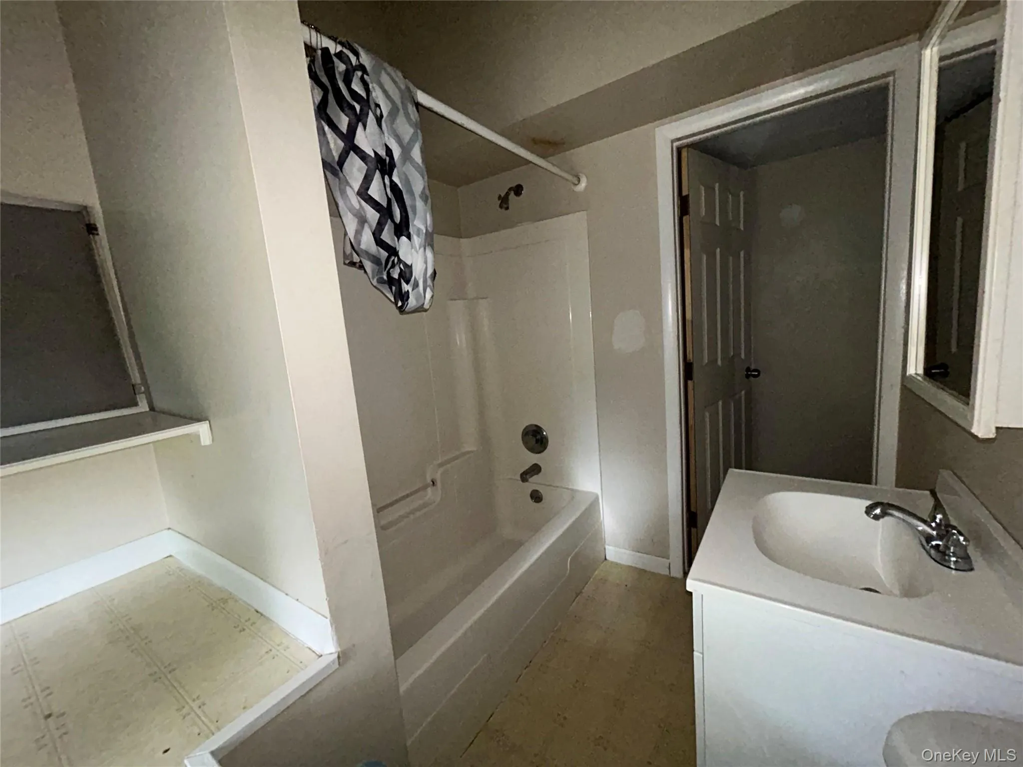 Bathroom featuring shower / tub combo, double vanity, and light flooring Bathroom featuring shower / tub combo, double vanity, and light flooring