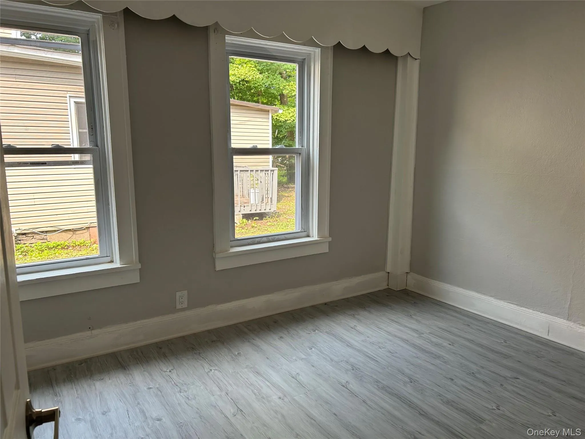 Empty room with healthy amount of natural light and light wood-style floors Empty room with healthy amount of natural light and light wood-style floors