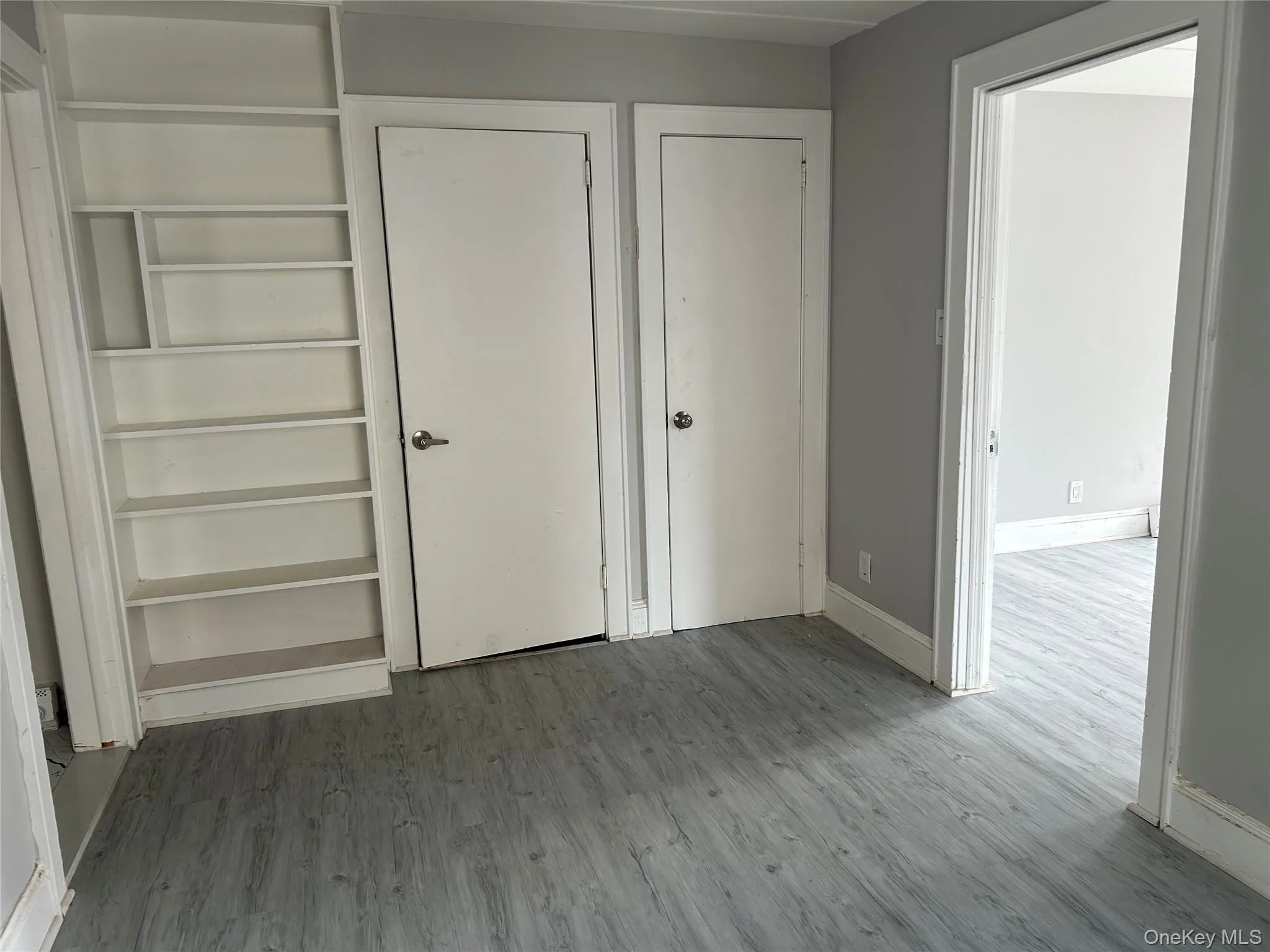 Unfurnished bedroom featuring dark wood-style flooring Unfurnished bedroom featuring dark wood-style flooring