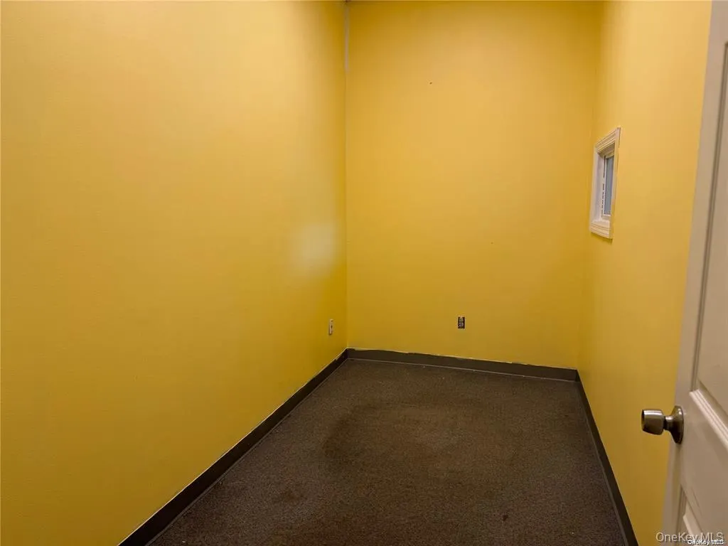 Spare room with dark colored carpet and baseboards Spare room with dark colored carpet and baseboards