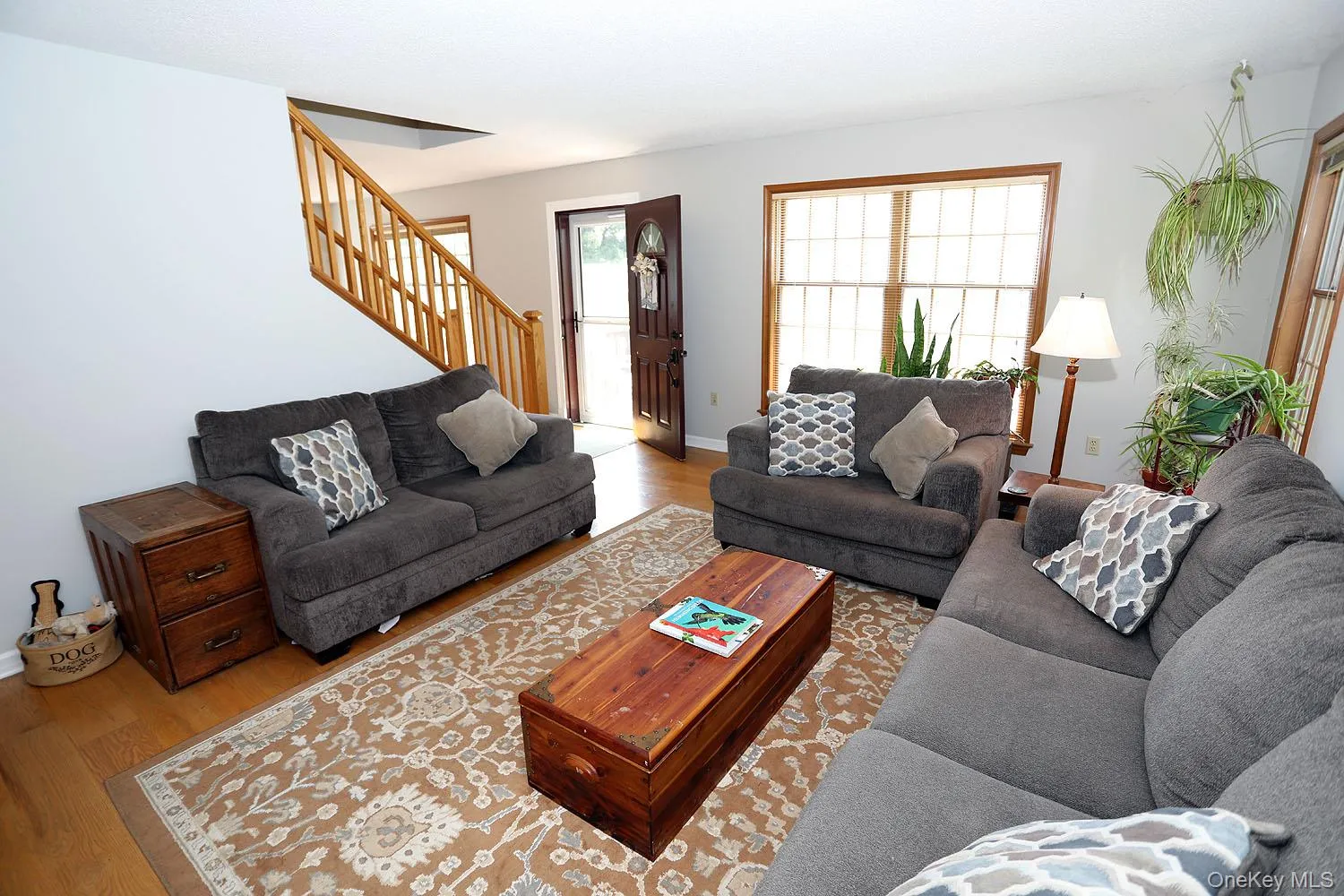 Living room featuring wood finished floors and stairs Living room featuring wood finished floors and stairs