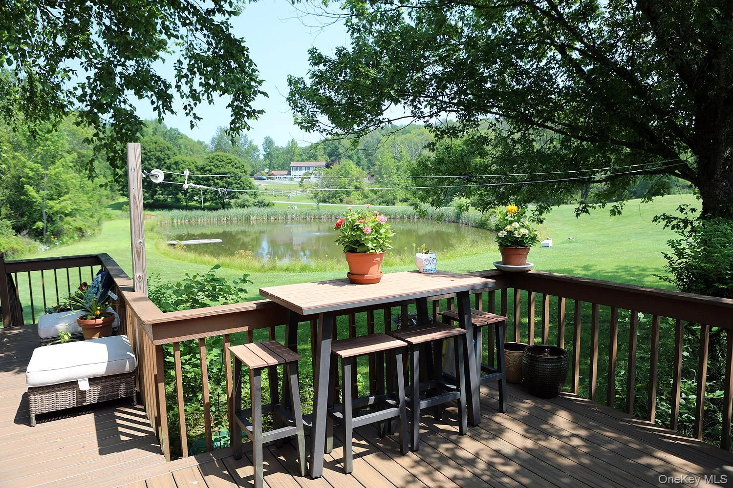 Deck featuring a water view, a yard, and view of wooded area Deck featuring a water view, a yard, and view of wooded area