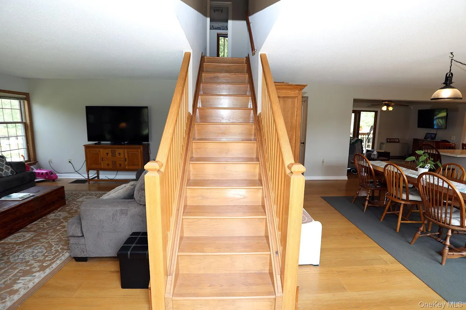 Staircase featuring wood finished floors and ceiling fan Staircase featuring wood finished floors and ceiling fan