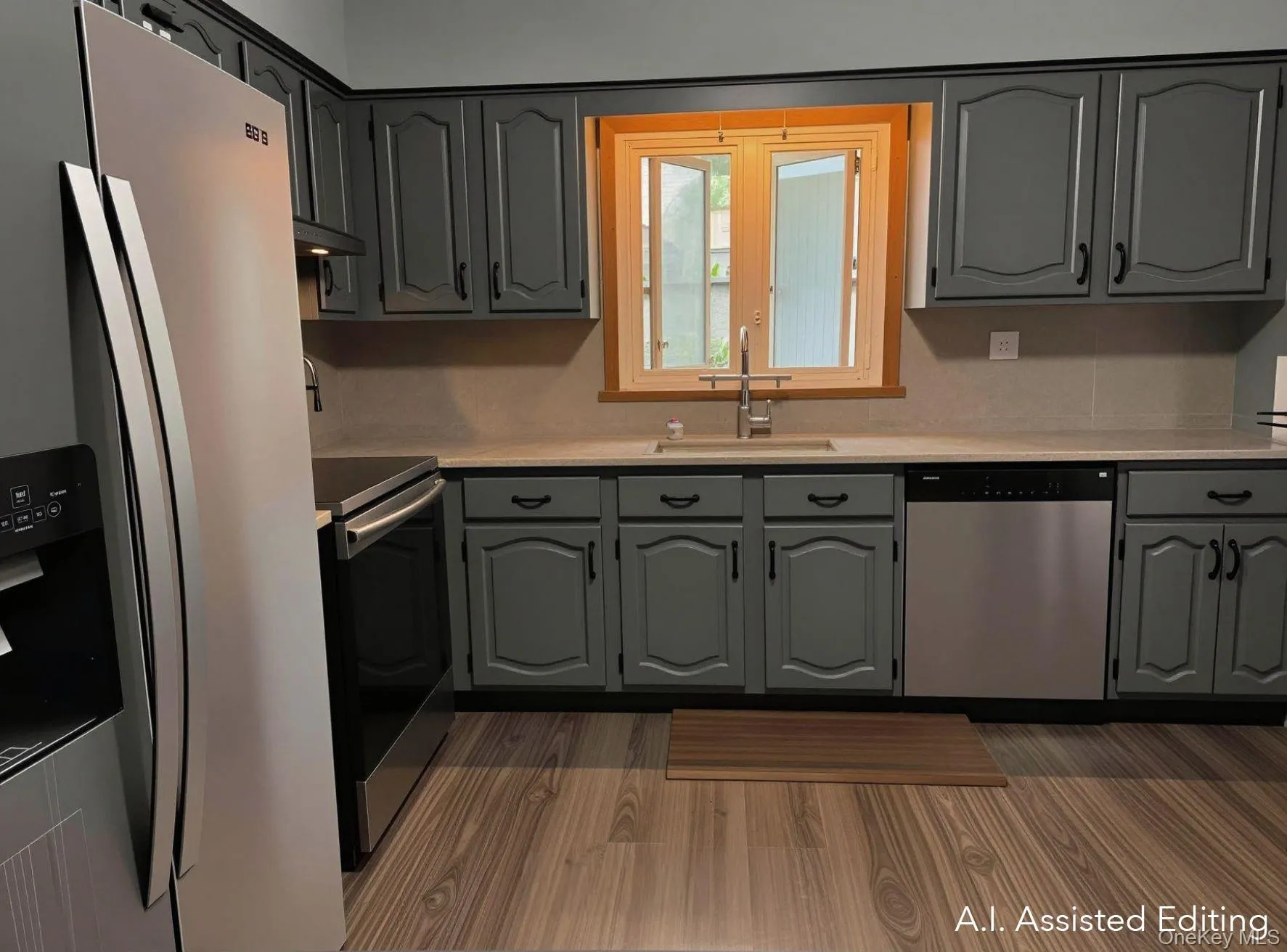 Kitchen featuring mid tone steel gray cabinetry, stainless steel appliances, light countertops, and wood-finish LVT flooring Kitchen featuring mid tone steel gray cabinetry, stainless steel appliances, light countertops, and wood-finish LVT flooring